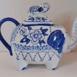 A vintage blue and white ceramic teapot shaped like an elephant